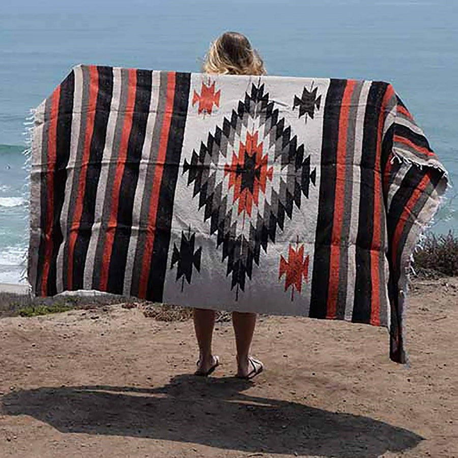 Woman spreading blanket out near beach