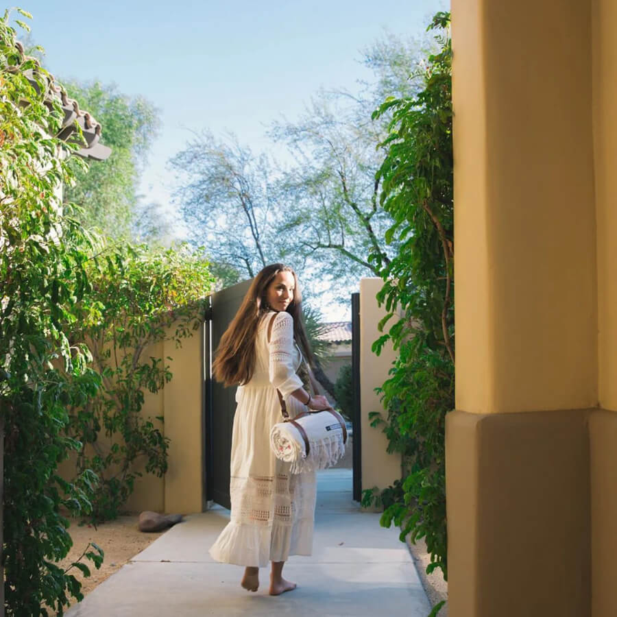 woman walking with leather blanket carrying straps